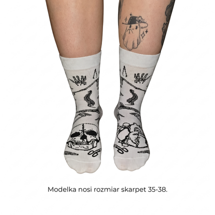Osoba ma na stopach białe długie bawełniane skarpety z motywem rycin anatomicznych od Love Your Inside. Modelka nosi rozmiar skarpet 35–38.